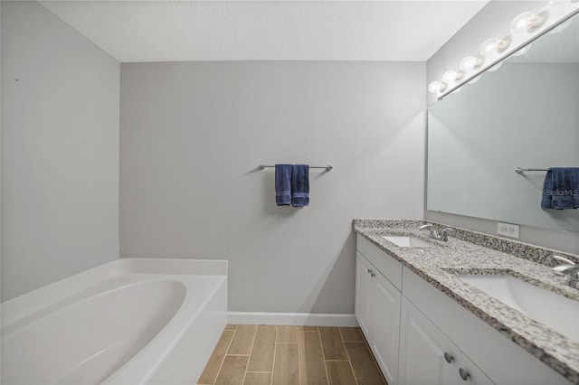 bathroom with vanity, a textured ceiling, and a bathing tub