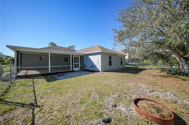 rear view of property with a yard and a sunroom