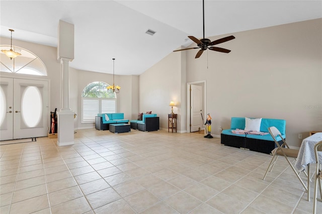 tiled foyer entrance with ceiling fan with notable chandelier, high vaulted ceiling, french doors, and ornate columns