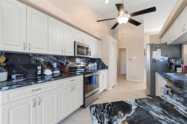 kitchen with backsplash, light tile patterned floors, white cabinets, and appliances with stainless steel finishes