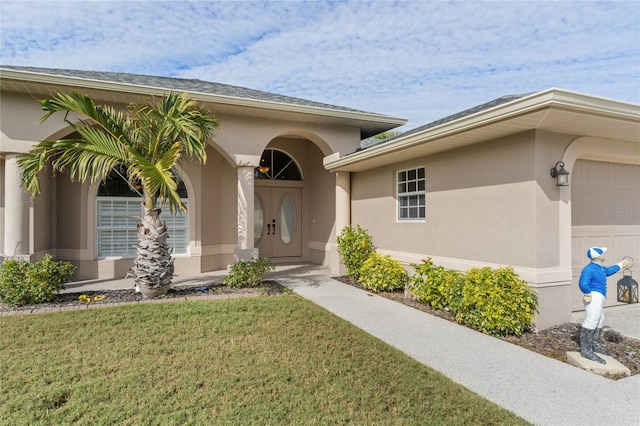 property entrance with a garage and a lawn