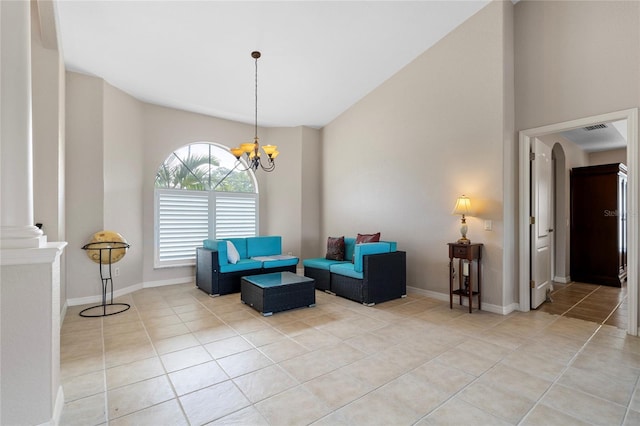 sitting room with a notable chandelier, ornate columns, and light tile patterned flooring