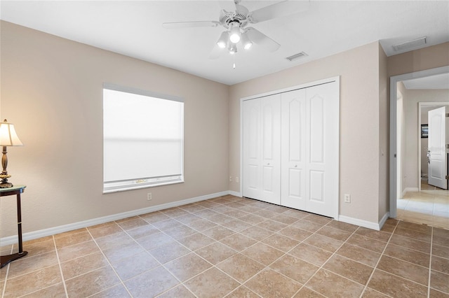 unfurnished bedroom with light tile patterned floors, a closet, and ceiling fan