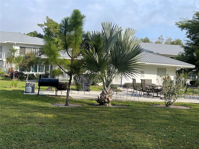 view of home's community featuring a patio area and a lawn