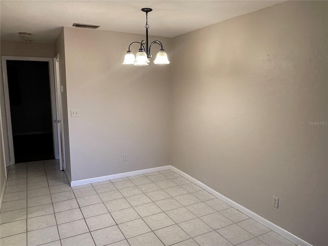 spare room with baseboards, a chandelier, and light tile patterned flooring