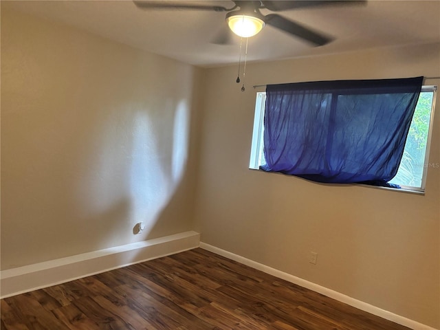 empty room with dark wood-style floors, ceiling fan, and baseboards