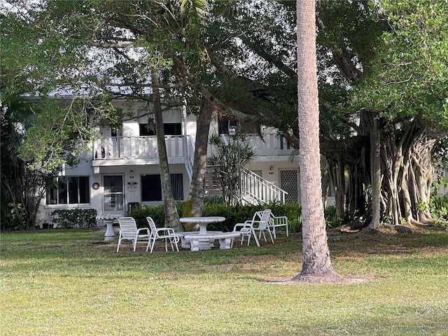 exterior space with a lawn, a balcony, and stucco siding