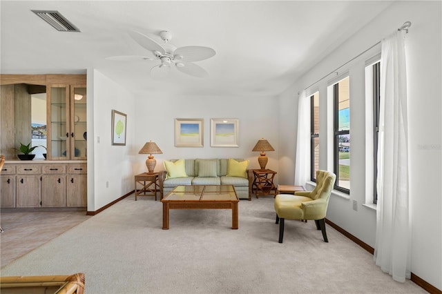 living room featuring light colored carpet and ceiling fan