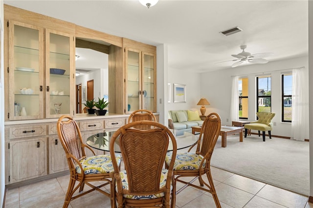 dining space with light carpet and ceiling fan