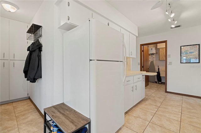 kitchen with ceiling fan, white cabinetry, track lighting, light tile patterned flooring, and white fridge