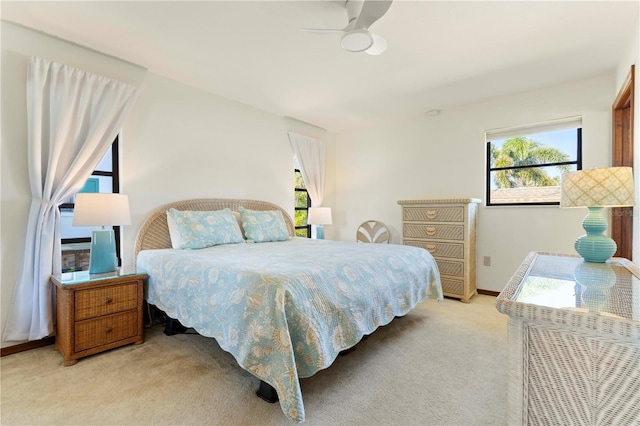 carpeted bedroom featuring multiple windows and ceiling fan