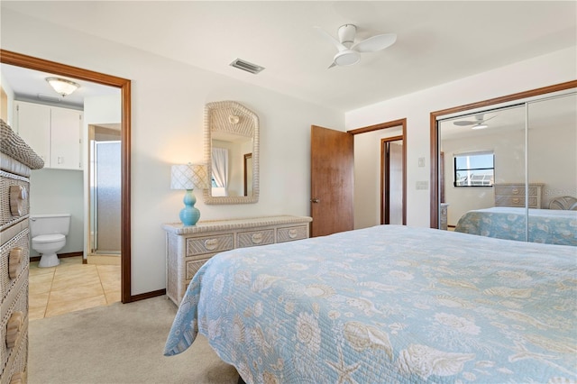 bedroom featuring connected bathroom, light tile patterned floors, a closet, and ceiling fan