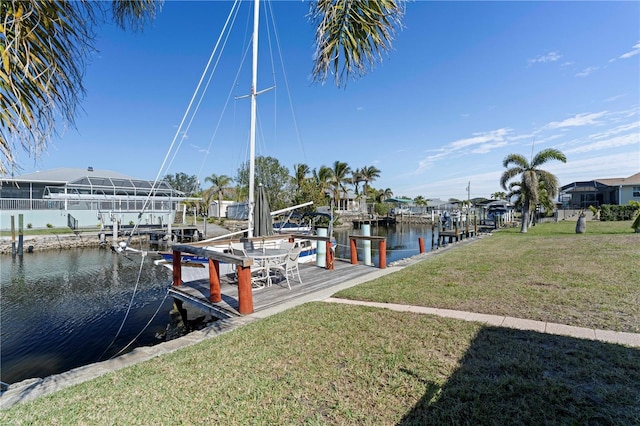 view of dock with a yard and a water view