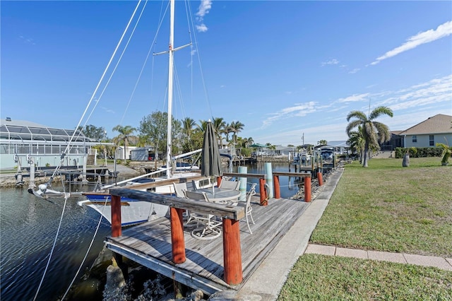 view of dock with a yard and a water view