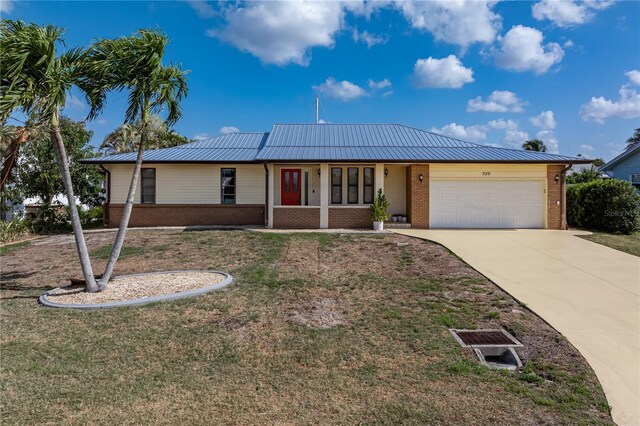 520 Boardman Dr, Punta Gorda, FL 33950 - ranch-style house with a garage, concrete driveway, a front lawn, metal roof, and brick siding