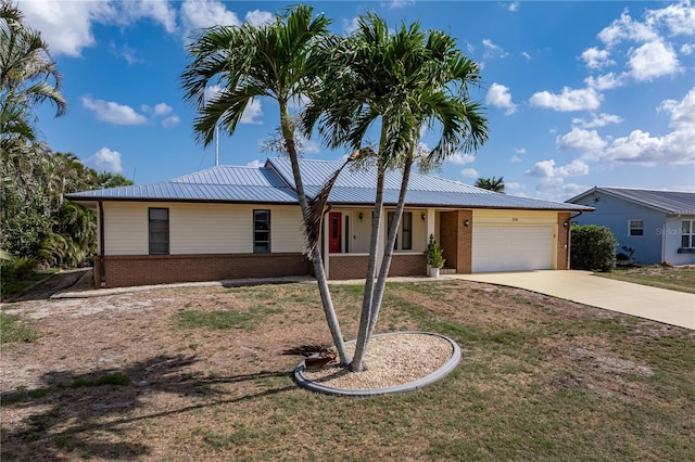 520 Boardman Dr, Punta Gorda, FL 33950 - single story home with a garage, concrete driveway, a front lawn, metal roof, and brick siding