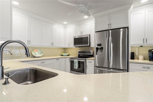 kitchen with stainless steel appliances, sink, white cabinets, and decorative backsplash