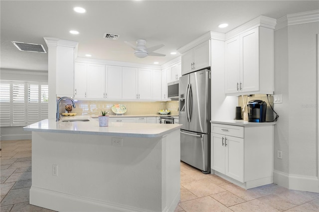 kitchen featuring sink, ceiling fan, stainless steel appliances, white cabinets, and kitchen peninsula