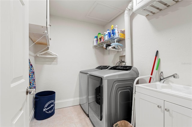 laundry room featuring cabinets, light tile patterned flooring, washer and dryer, and sink