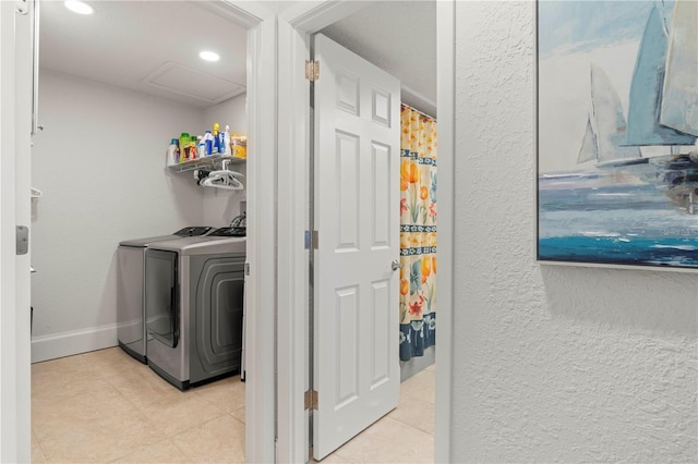 laundry room with washing machine and dryer and light tile patterned flooring