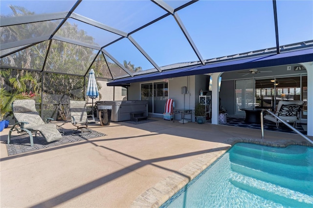 view of swimming pool with ceiling fan, a patio, a hot tub, and glass enclosure