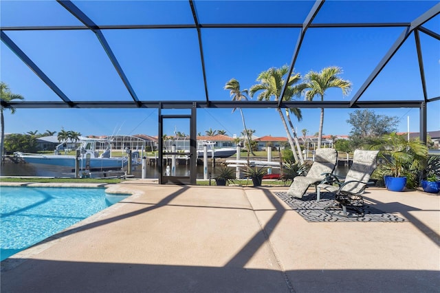 view of swimming pool with a patio, a water view, and a lanai