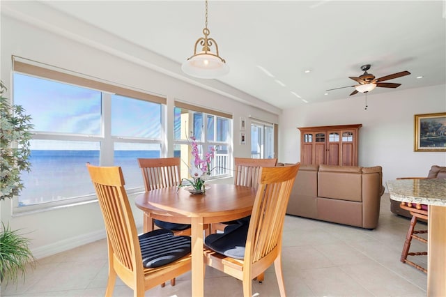 tiled dining room featuring a water view and ceiling fan