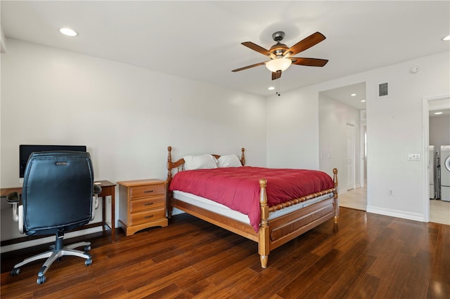 bedroom featuring ceiling fan, dark hardwood / wood-style floors, and washing machine and dryer