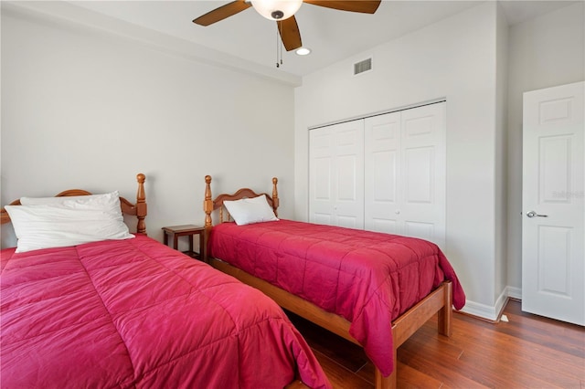 bedroom with dark hardwood / wood-style flooring, a closet, and ceiling fan