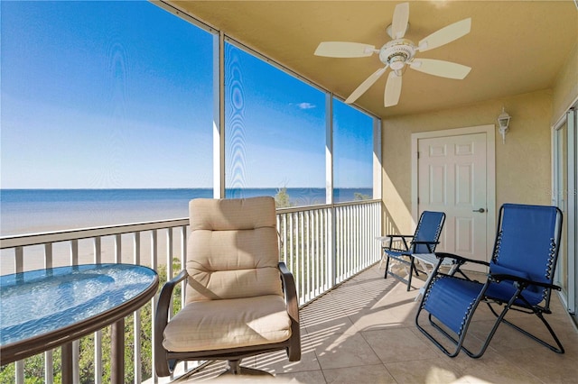 sunroom featuring a water view, plenty of natural light, a beach view, and ceiling fan