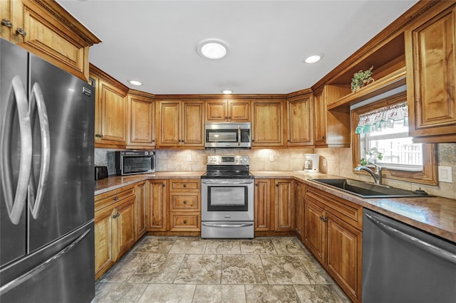 kitchen featuring stainless steel appliances, sink, and decorative backsplash