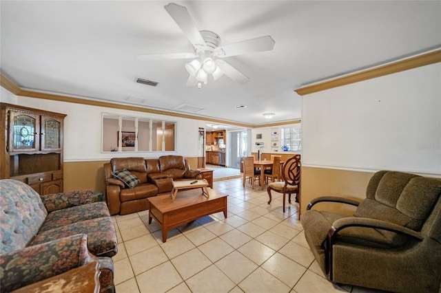 living room with crown molding, ceiling fan, and light tile patterned flooring