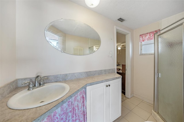 bathroom featuring walk in shower, tile patterned floors, a textured ceiling, and vanity