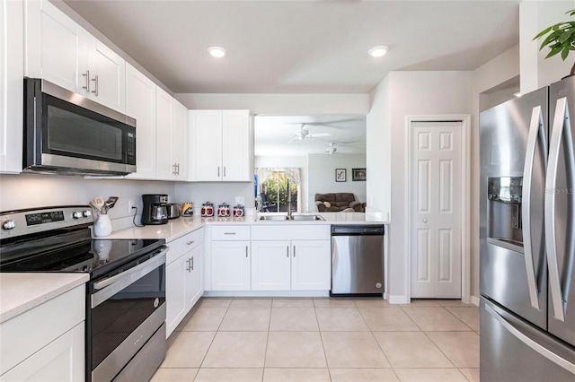 kitchen featuring sink, light tile patterned floors, ceiling fan, white cabinetry, and stainless steel appliances