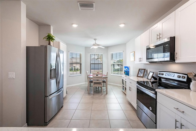 kitchen featuring white cabinetry, ceiling fan, stainless steel appliances, and light tile patterned floors