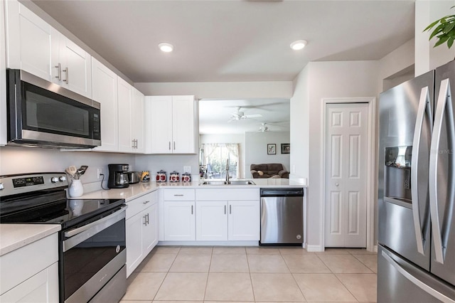 kitchen with ceiling fan, stainless steel appliances, and white cabinets