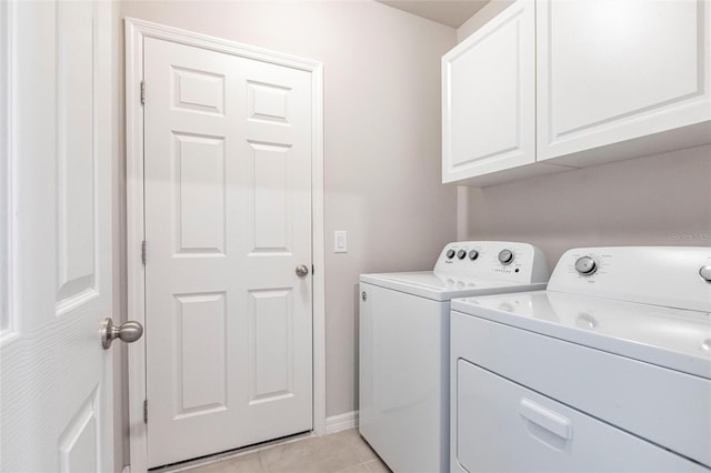 laundry area with cabinets, independent washer and dryer, and light tile patterned floors