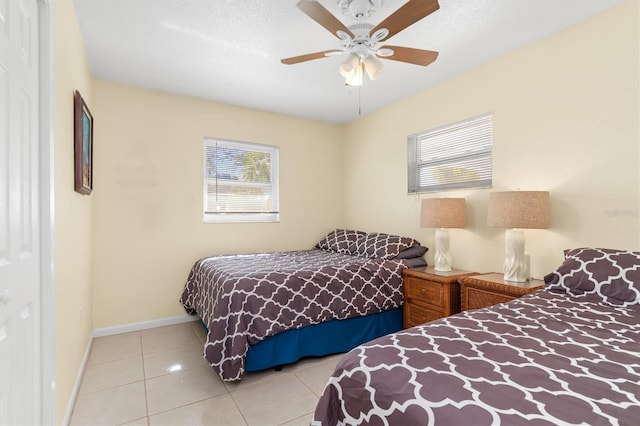 tiled bedroom featuring a textured ceiling and ceiling fan