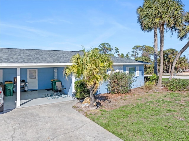 view of front facade featuring a front lawn and a carport