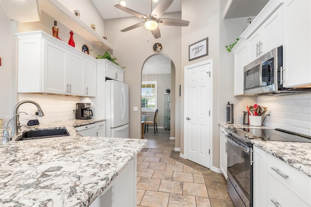 1020 Caliva St, North Port, FL 34286 - kitchen with appliances with stainless steel finishes, a sink, a ceiling fan, baseboards, and stone tile flooring