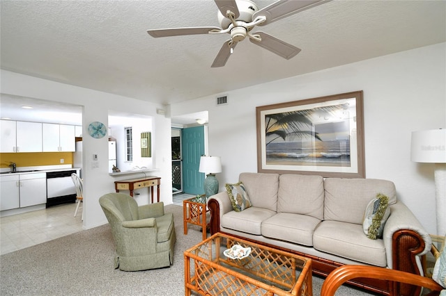 tiled living room with ceiling fan, sink, and a textured ceiling