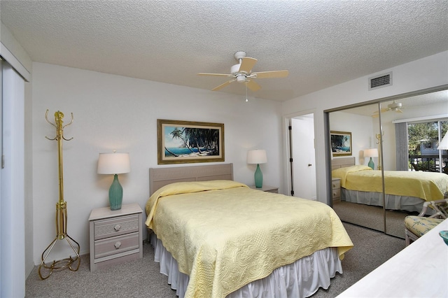 bedroom with carpet flooring, a textured ceiling, ceiling fan, and a closet