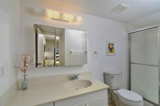 bathroom with a shower with door, vanity, and toilet