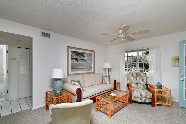 living room with ceiling fan, light carpet, and a textured ceiling