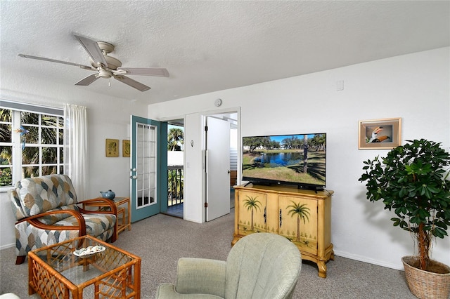 living room featuring ceiling fan, carpet, and a textured ceiling