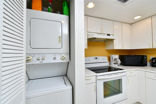 kitchen featuring white cabinetry, white electric range, and stacked washer / dryer