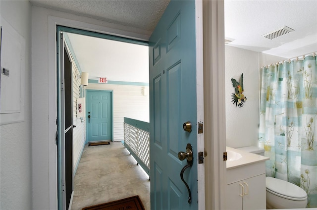 bathroom featuring vanity, toilet, and a textured ceiling