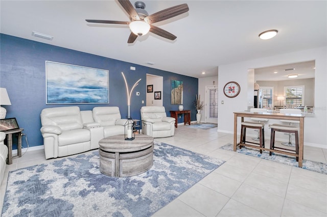 living room featuring light tile patterned floors and ceiling fan