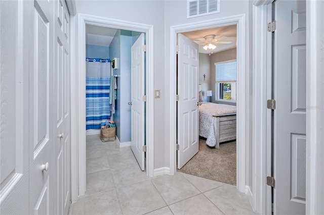 hallway featuring light colored carpet