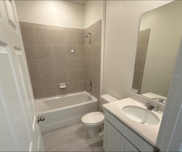 bathroom featuring vanity, toilet, and washtub / shower combination